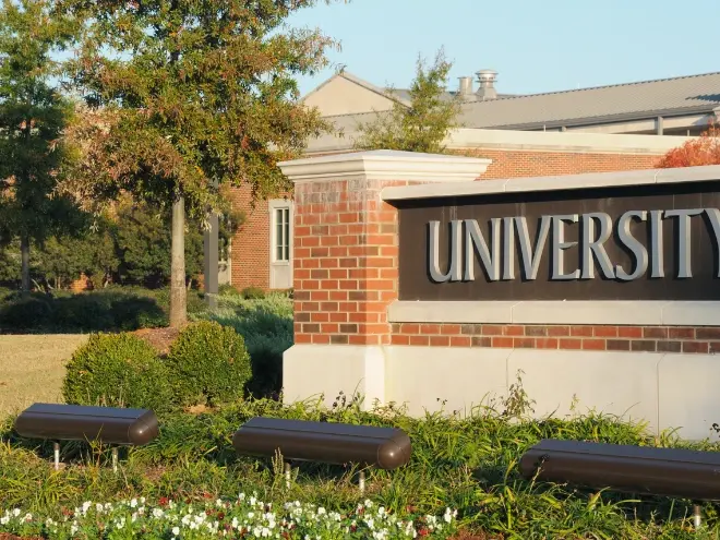 University campus with academic buildings and students walking between classes.