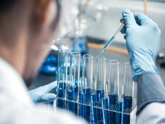 Scientists working in a sterile biotech laboratory with advanced equipment.